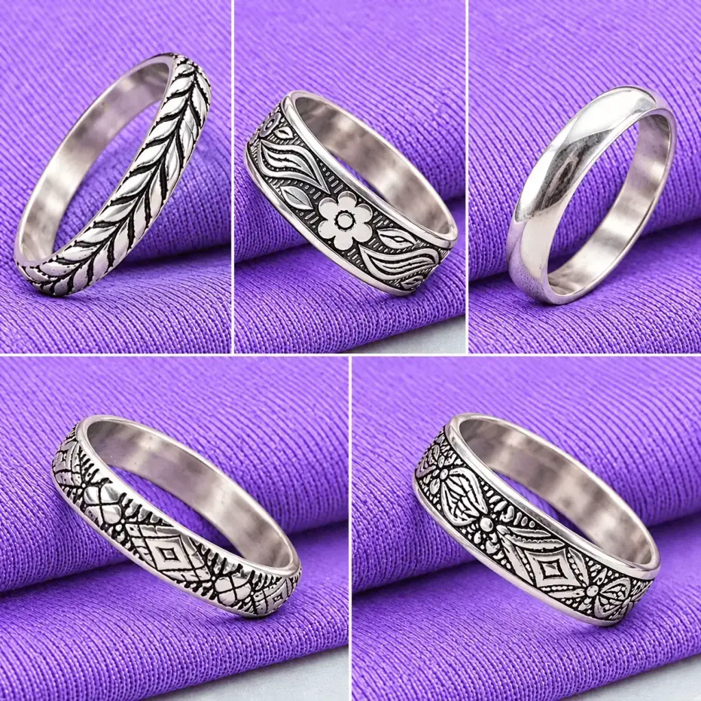 Flat lay arrangement of the five artisan handcrafted rings scattered on a lavender fabric, showcasing their unique individual