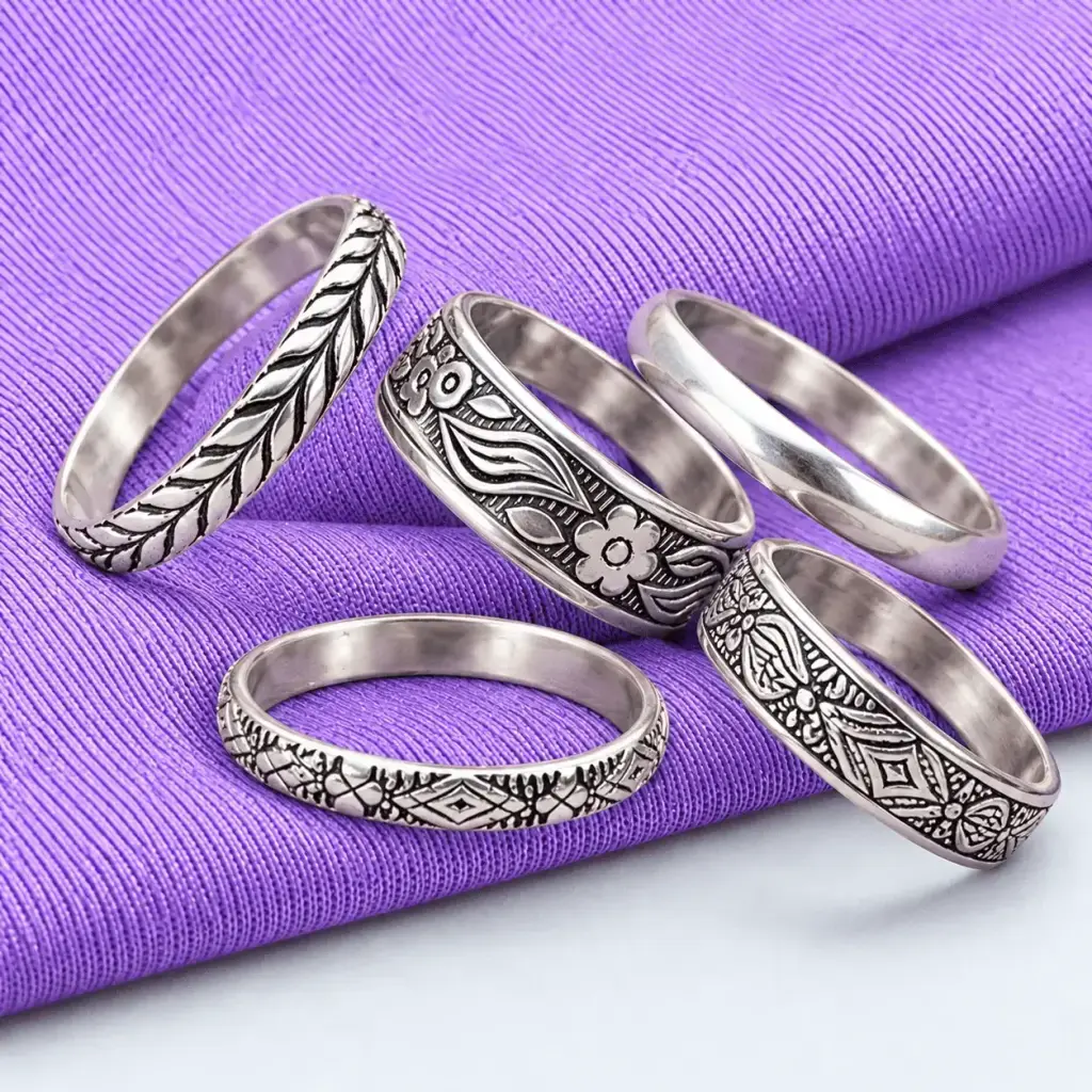 Close view of the five vintage style silver rings stacked neatly together, showing the beautiful contrast of varying metal te